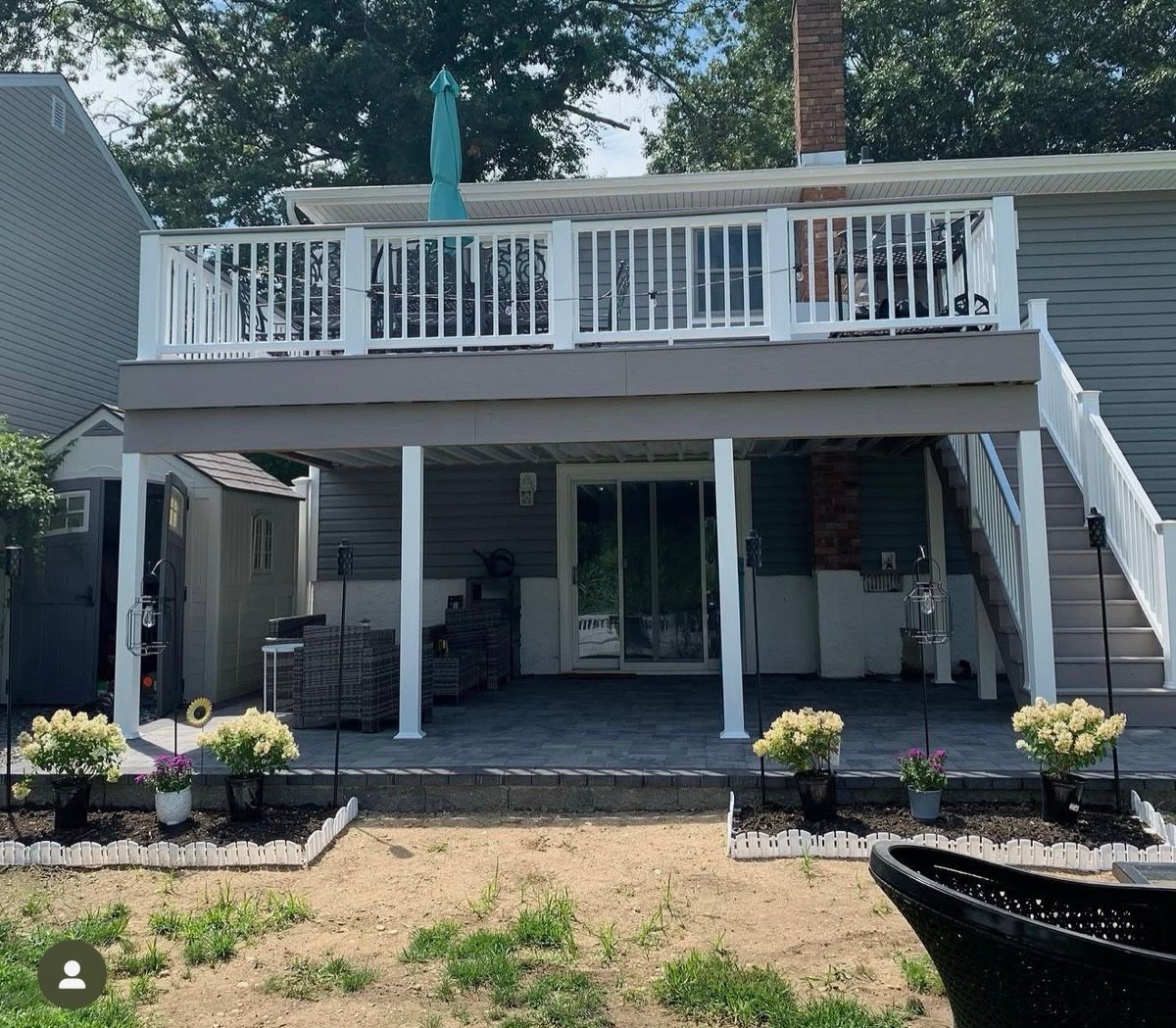 After — finished white-railed deck with paver patio below